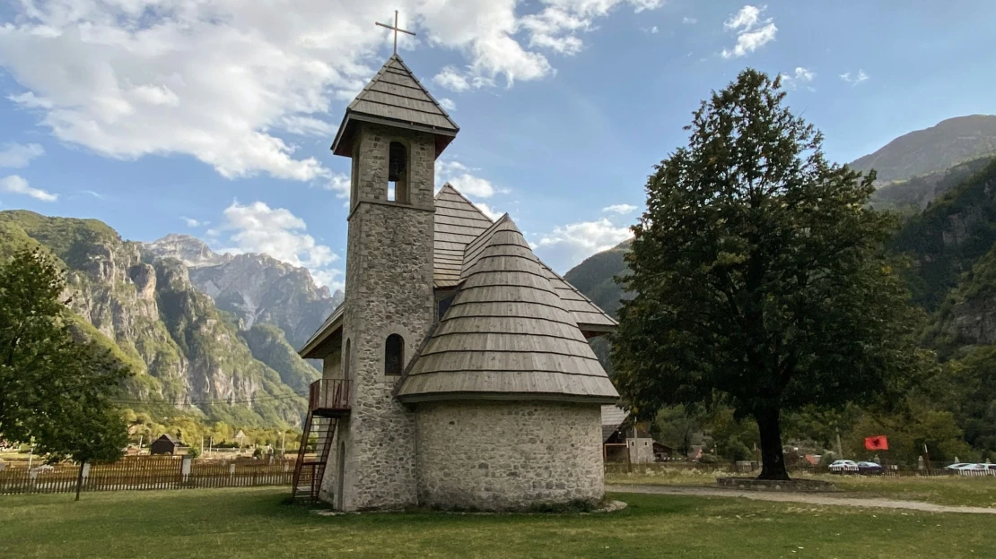 Prach a suť kolem fotoikony Albánie. Bagry čistí panoráma od černých staveb